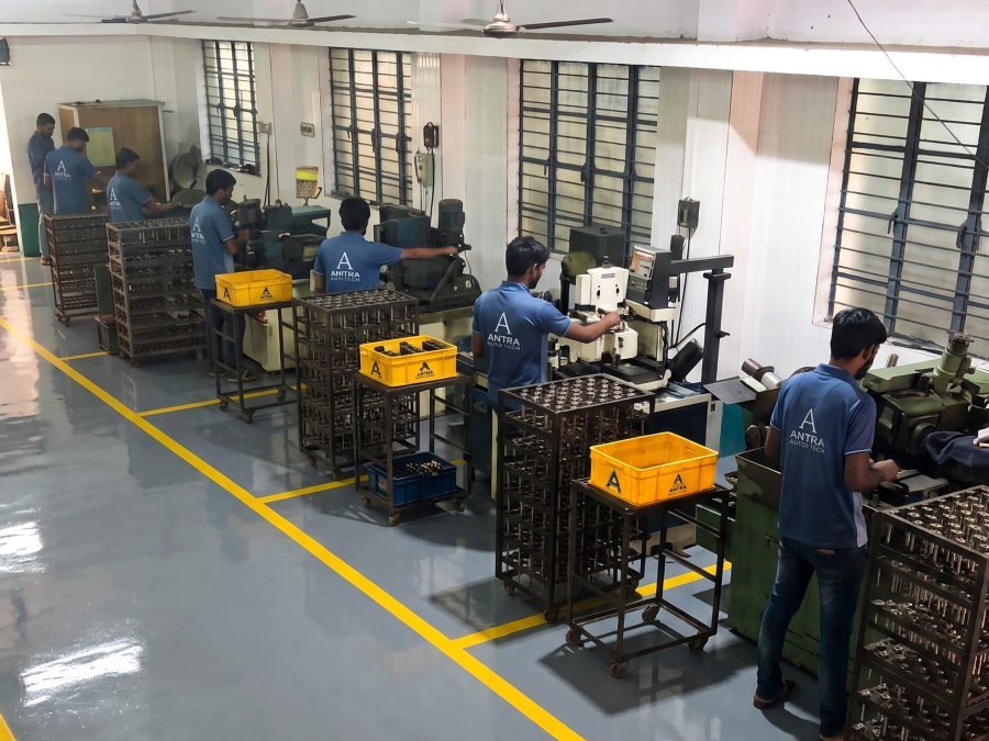Grinding machines in operation with racks and crates of valves being loaded and unloaded